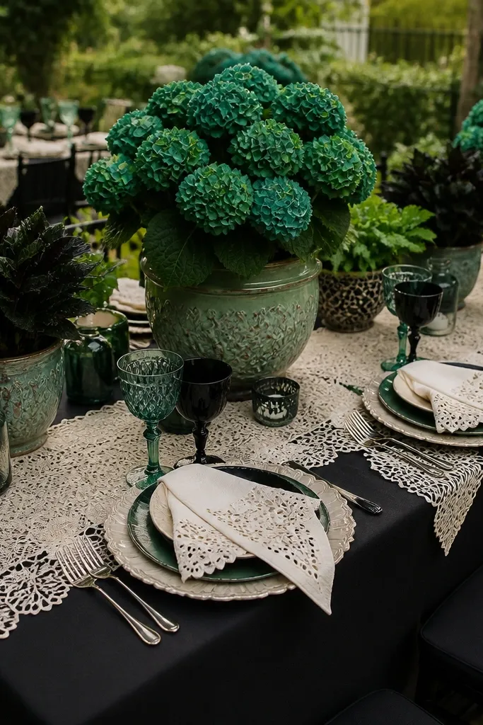 Dramatic wedding table setting with black linens, deep emerald florals, and delicate ivory lace detailing